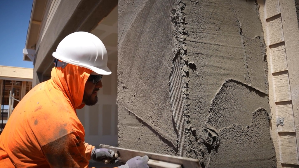 Worker installing stucco