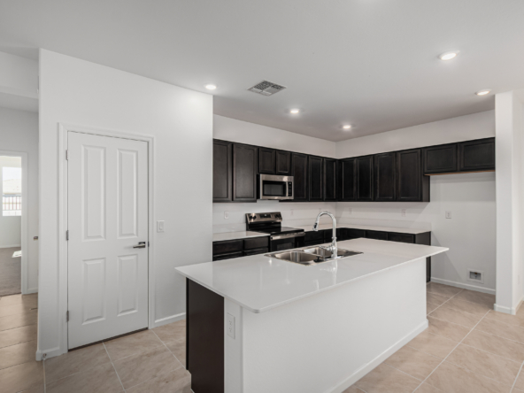 Discovery RV home's kitchen with espresso cabinets and white quartz