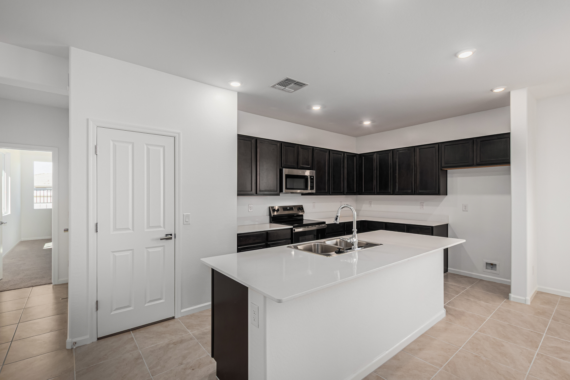 Discovery RV home's kitchen with espresso cabinets and white quartz