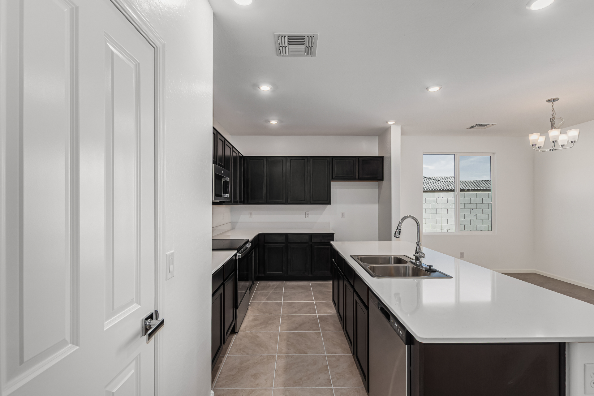 Discovery RV home's kitchen with espresso cabinets and white quartz