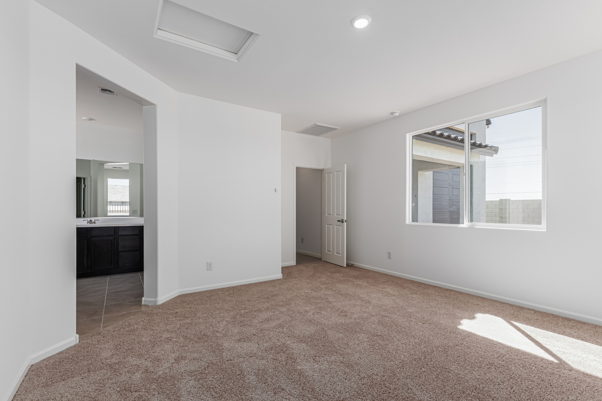 Discovery RV home master bedroom with a view into the bathroom