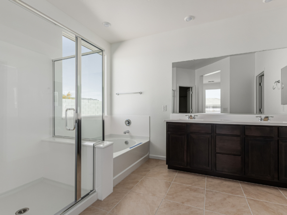 Discovery RV home master bath featuring a step in shower and seperate bathtub