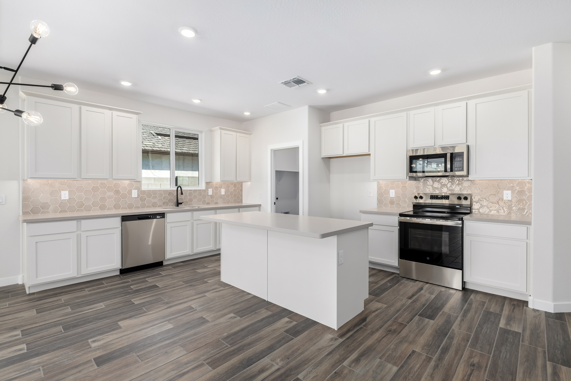 holly kitchen with soft white cabinets and a greige honeycomb backsplash