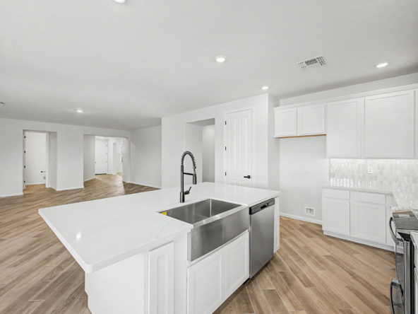 kitchen of the journey plan featuring white cabinets and a farmhouse sink