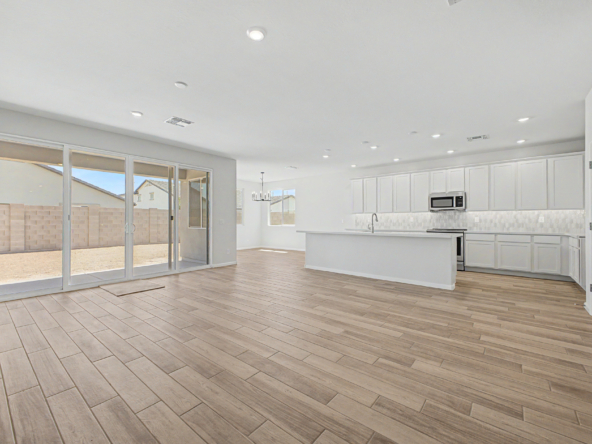 Great room view of a violet 4414 floor plan featuring white cabinets and a large sliding glass door